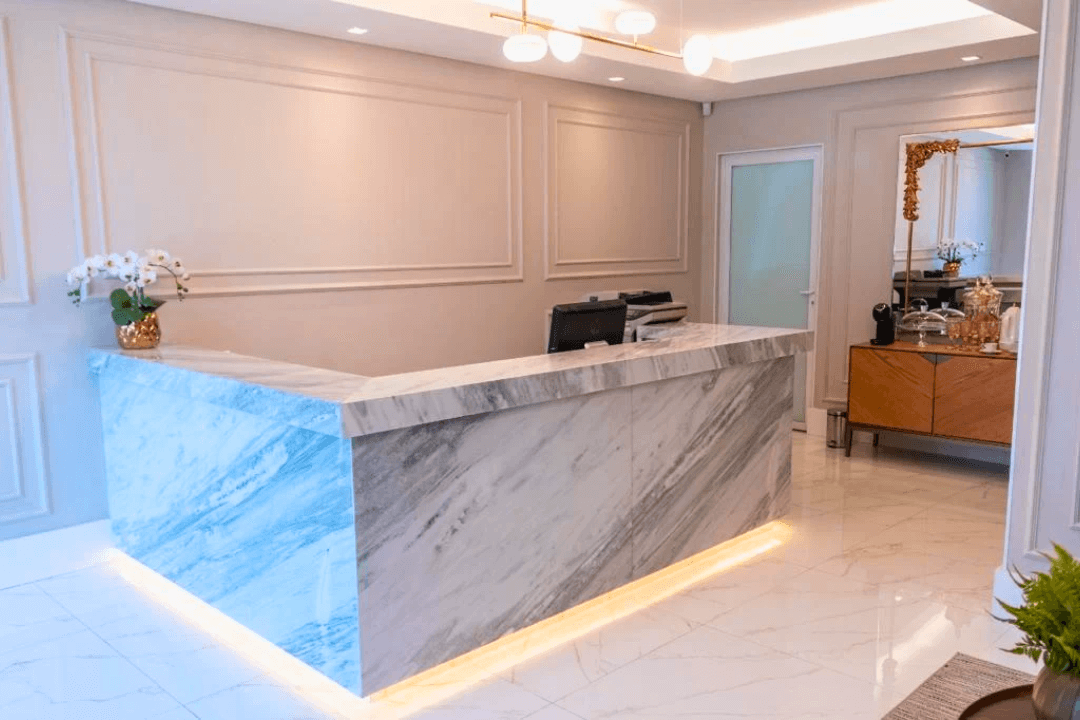 Detalhe do balcão de atendimento em mármore, transmitindo a solidez e seriedade da empresa contábil.